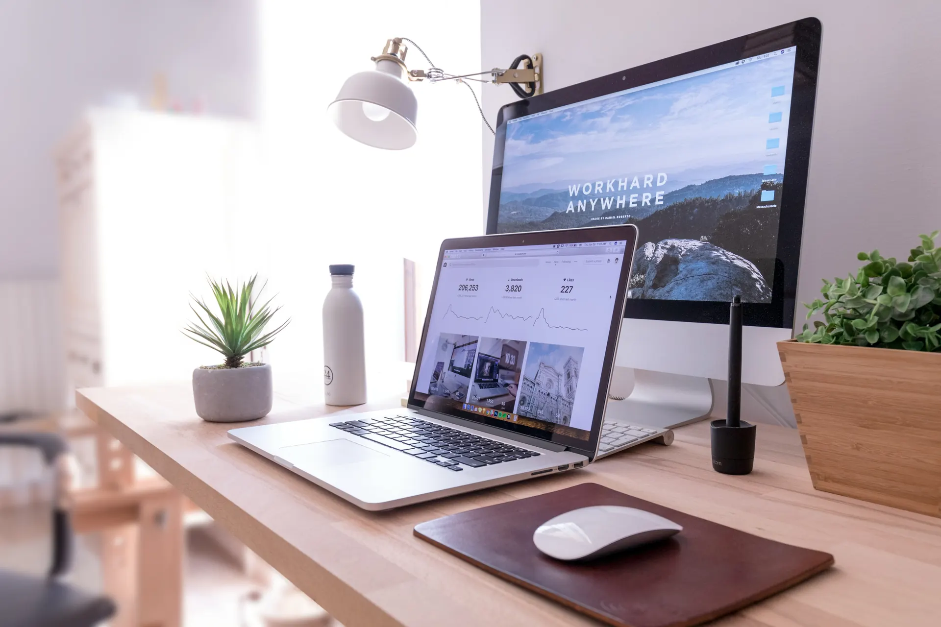 Desktop and laptop workspace showing digital work across screens